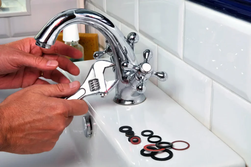 Plumber performing maintenance on a bathroom faucet in Coral Gables