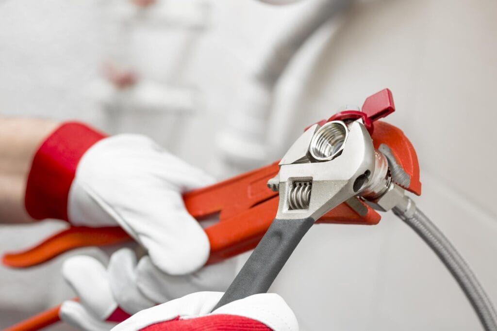 Plumber holding pipe wrenches for an emergency repair in Coral Gables
