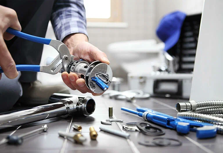 Technician repairing a plumbing fixture with professional tools in Coral Gables