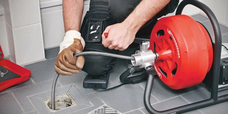 Plumber using a drain-cleaning machine in Coral Gables