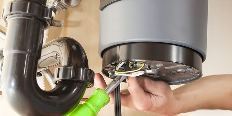 Technician repairing the heating element of a water heater in Coral Gables