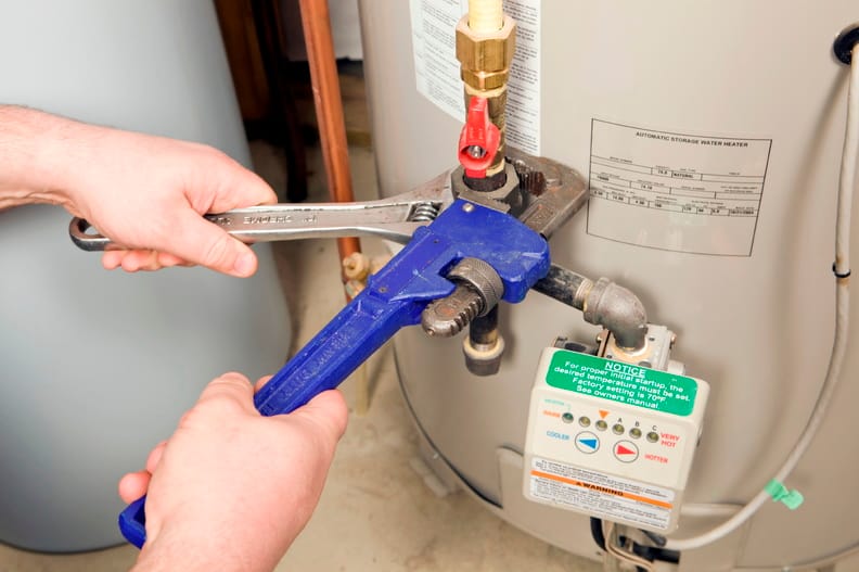 Plumber repairing a water heater valve in Coral Gables